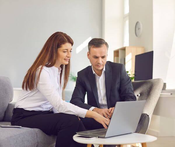 two people looking at a laptop employing your spouse