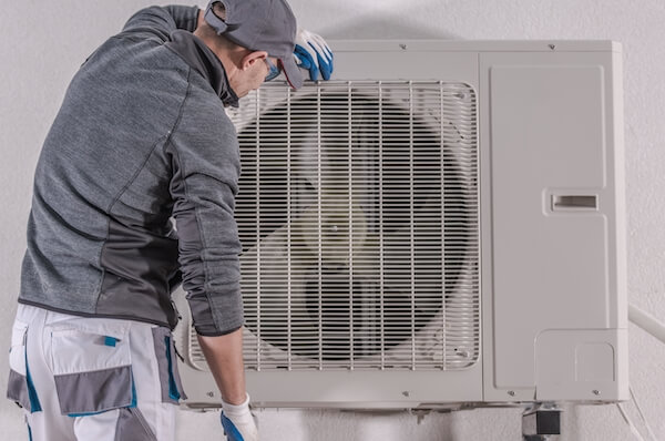 a man fixing a heat pump energy tax credits