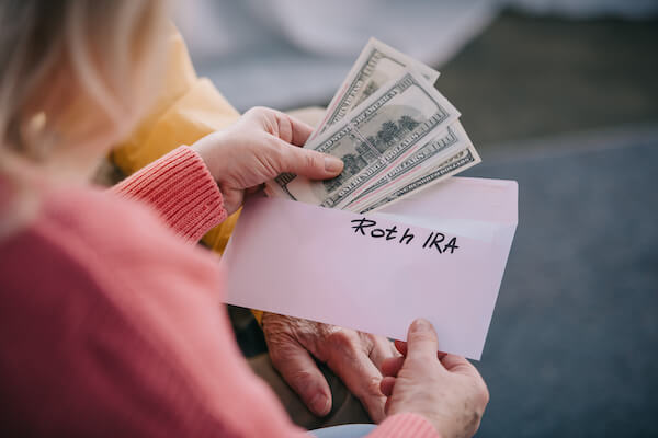 a woman putting currency into an envelope 6 year-end financial strategies